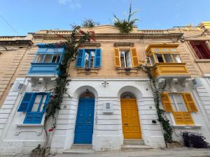 a building with blue and yellow doors and windows at The Maltese Sun in Sliema
