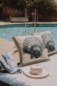 a table with hats and pillows next to a pool at Hotel de Mar Gran Meliá - Adults Only - The Leading Hotels of the World in Illetas