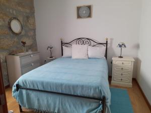 a bedroom with a bed and a dresser and a mirror at Alojamento São Lourenço in Viseu