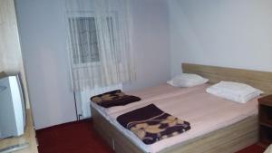 a bedroom with a bed with two pillows on it at Holiday Home Čarobna Kućica in Pale