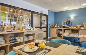 a dining room with a table and chairs and a cafeteria at Résidence Odalys Archipel in La Rochelle