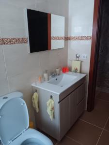 a bathroom with a blue toilet and a sink at Alojamento São Lourenço in Viseu