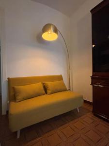 a couch sitting in a room with a lamp at Casa Emma Homestay in Alba city center in Alba