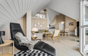 a living room and dining room with a black chair at Lyngbo in Havrvig