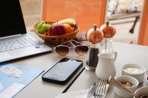 a table with a laptop computer and a bowl of fruit at The Maltese Sun in Sliema