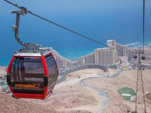 a red cable car flying over a city at Porto Sokhna Majestic in Ain Sokhna +5 photos