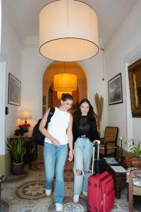 two women walking through a living room with a suitcase at The Maltese Sun in Sliema