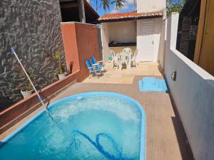 a swimming pool with a hose in a backyard at Sol & Vento Chalés - Chalé Tourinhos com piscina privativa in São Miguel do Gostoso