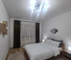 a bedroom with a white bed and a window at Apartment Andrin in Gostivar