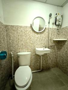une salle de bains avec toilettes, lavabo et miroir dans l'établissement Bann Chana BKK, à Bangkok
