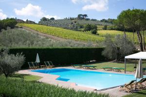 a swimming pool with chairs and umbrellas in a yard at Tenuta San Filippo in Montalcino