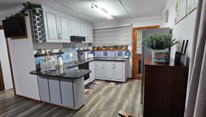 a kitchen with white cabinets and a black counter top at The Big tree @ Sabie in Sabie