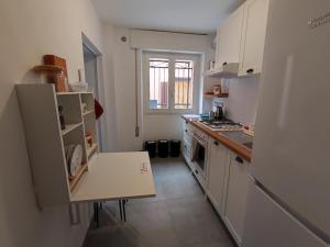 a kitchen with white cabinets and a table in it at Casa delle zie Savoretti in San Clemente