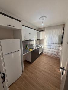 a kitchen with white cabinets and a white refrigerator at İlkay suit in Bandırma