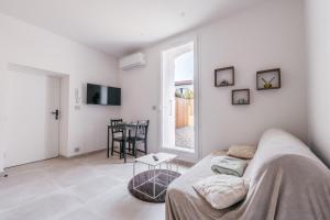 a white living room with a couch and a table at Chic T2 climatisé proche plages in Châteauneuf-lès-Martigues