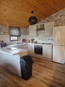 a kitchen with white cabinets and a black trash can at Wild Oats Lodge 19, Yellowtop Country Park in Selby +15 photos