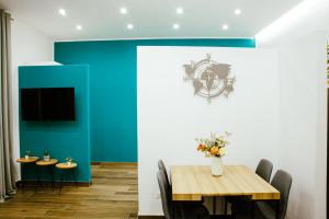 una sala da pranzo con tavolo e parete blu di Chiaia Exclusive Apartment a Napoli
