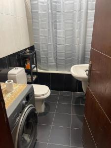 a bathroom with a washing machine and a sink at Samar Home in Amman