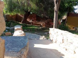 a stone wall in a garden with a bench at La Pirquita in Tilcara