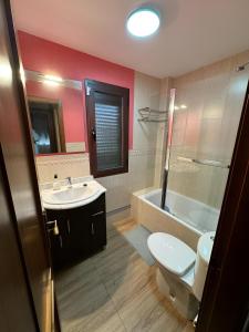 a bathroom with a toilet and a sink and a tub at Casa Rural Rincón del Lago in El Ronquillo