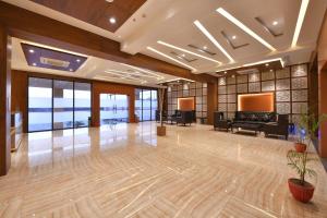 a large lobby with a piano and a television at Clubhouse Hotel Morbi in Morbi