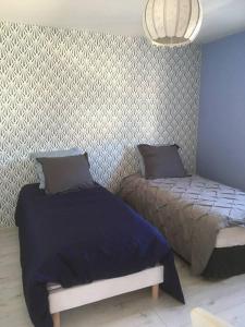 a bedroom with two beds and a wall at MAISON DE VACANCES 4 Clés - BORD DE MER DENNEVILLE PLAGE in Denneville