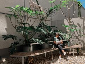 a woman sitting on a bench in a garden at Cómodo departamento centro de Salta by BEDBOOK in Salta
