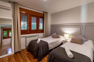 sypialnia z dwoma łóżkami i oknem w obiekcie RentitSpain Grand Luxury Villa Piscina & Jacuzzi Granada w mieście Albolote +56 zdjęć