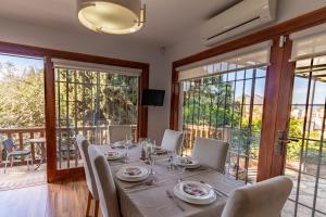 jadalnia ze stołem, krzesłami i oknami w obiekcie RentitSpain Grand Luxury Villa Piscina & Jacuzzi Granada w mieście Albolote