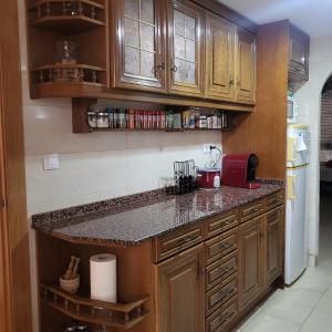 a kitchen with wooden cabinets and a counter top at Habitación en centro de Alicante in Alicante