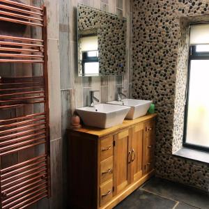 a bathroom with two sinks and a mirror at The Stables in St Ives in St Ives