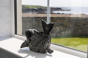 a statue of a fish sitting on a window sill at Sheerghlass in Castletown