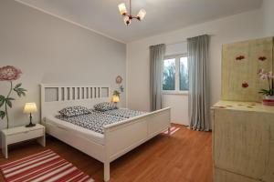 Un dormitorio blanco con una cama y una ventana. en Villa Mirkov San, en Pakovo Selo 58 fotos más