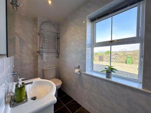 a bathroom with a sink and a toilet and a window at Sheerghlass in Castletown