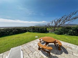 a wooden bench sitting on a stone patio at Sheerghlass in Castletown
