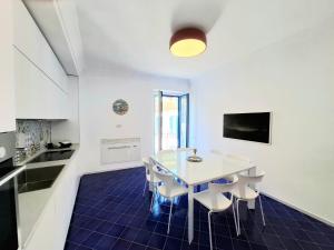 a kitchen and dining room with a white table and chairs at ELEONORA'S HOUSE Minori Main Square in Minori