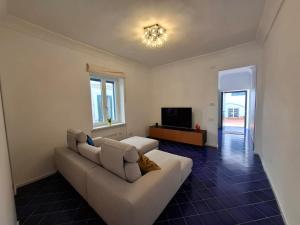 a living room with a white couch and a television at ELEONORA'S HOUSE Minori Main Square in Minori