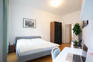 Un dormitorio con una cama y un escritorio con una computadora portátil. en Modern 3 Bedroom Apartment in City Center, en Viena