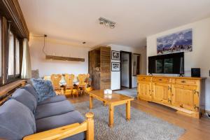 a living room with a couch and a table at Les Rocailles Apartment | 9 in La Tzoumaz