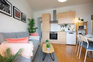 Una sala de estar y una cocina con un sofá y una mesa. en Modern 3 Bedroom Apartment in City Center, en Viena