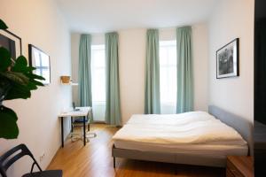 Un dormitorio con una cama, un escritorio y ventanas. en Modern 3 Bedroom Apartment in City Center, en Viena 19 fotos más