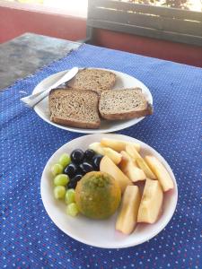 two plates of bread and fruit on a table at The Begnas sound healing center in Deorāli