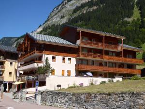 a large building on a hill next to a mountain at Appartement Confortable au Centre de Pralognan-la-Vanoise, Proche Téléphérique et Commerces - FR-1-464-107 in Pralognan-la-Vanoise