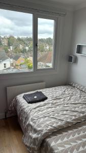 Una cama en un dormitorio con una ventana grande. en Family Home Away from Home, en Chatham