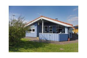 a blue house with a red roof at Ferienhaus Ty Glaz in Wesselburenerkoog