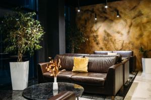 a leather couch and a table in a lobby at Favor Park Hotel in Kyiv