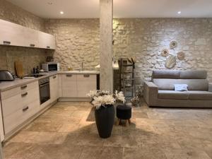 a living room with a couch and a kitchen at Un havre de paix au coeur de la Provence in Châteaurenard