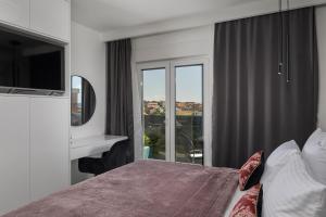 a bedroom with a bed and a tv and a window at Villa Depaja ZadarVillas in Zadar +28 photos