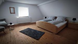 a white bedroom with a bed and a window at Ferienwohnung La Maison Palatinate in Kapsweyer