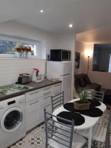 a kitchen with a table and a kitchen with a stove and a microwave at Othello Studio in Souillac